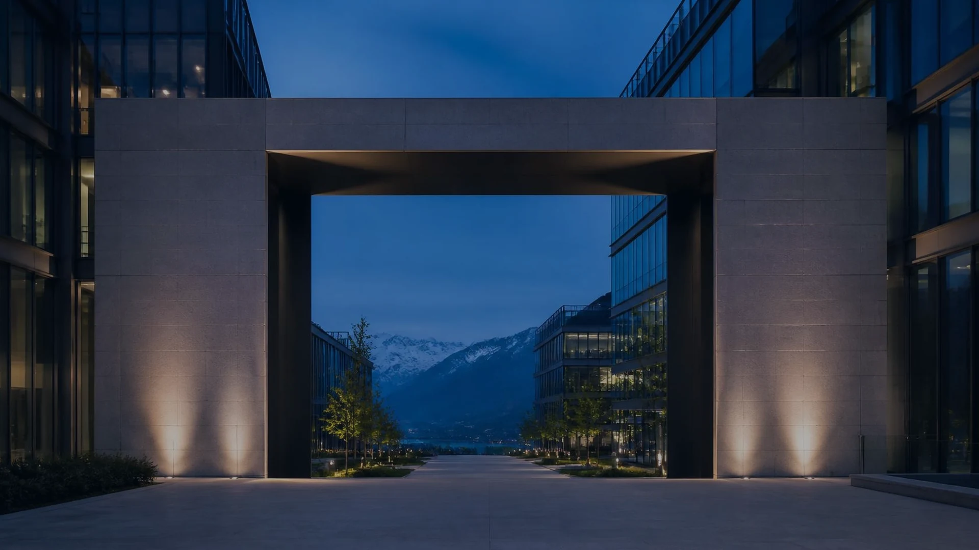 Modern Swiss business campus viewed through an architectural gateway toward the Alps.
